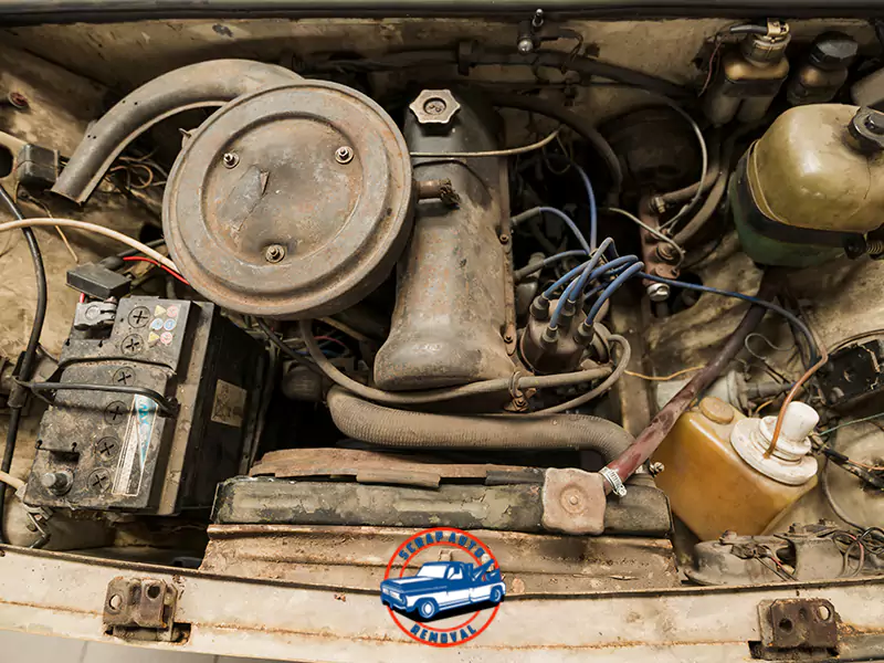 Dirty, vintage car engine bay with old components and wires, showing wear and tear, with a Scrap Auto Removal logo.
